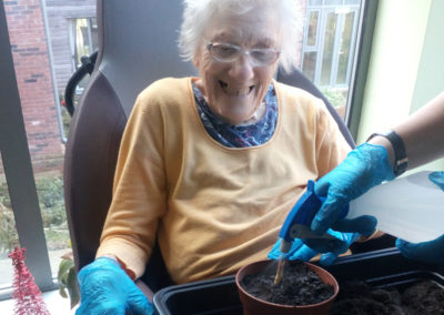 Hengist Field resident potting and watering a plant