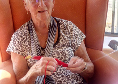 One of the ladies at Hengist Field Care Home knitting poppies for St Peter and St Paul Church in Borden