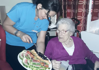 Resident choosing from a plate of delicious fresh fruits