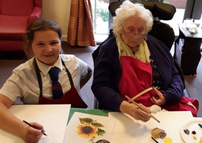 Oasis student with a resident from Hengist Field, working on sunflower paintings
