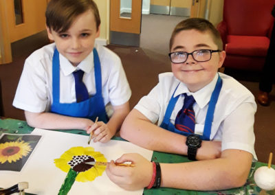 Two students from Oasis Academy painting a sunflower picture