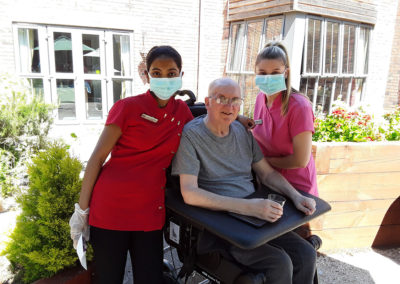 Resident with two staff members outside Hengist Field Care Home