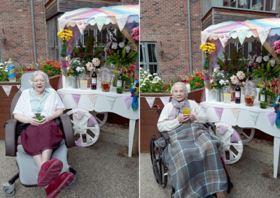 Two female residents at Hengist Field Care Home enjoying a drink in the garden