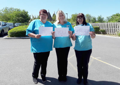 Staff at Hengist Field Care Home with a 'missing you already' sign for a member of staff who's leaving