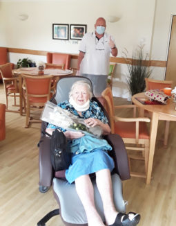 Hengist Field lady resident holding a flower bouquet and having a visit from her son