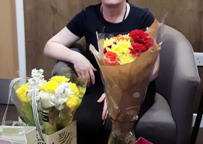 Nurse with her leaving gifts and flowers at Hengist Field Care Home