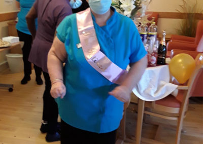 Staff member with her retirement on at Hengist Field Care Home