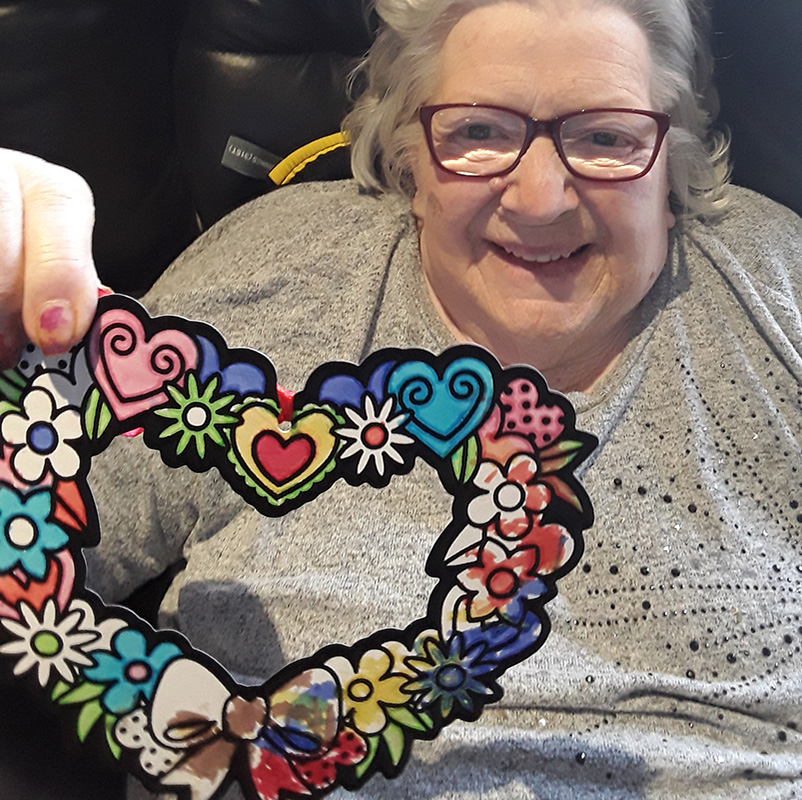 Hengist Field Care Home resident with her coloured heart decoration