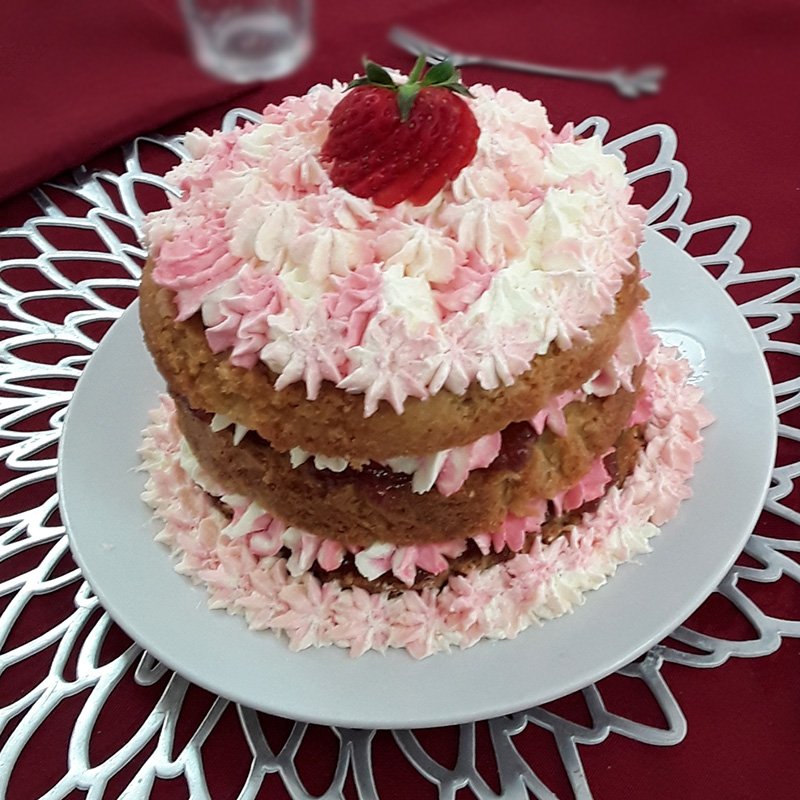Birthday cake with cream and a fresh strawberry at Hengist Field Care Home